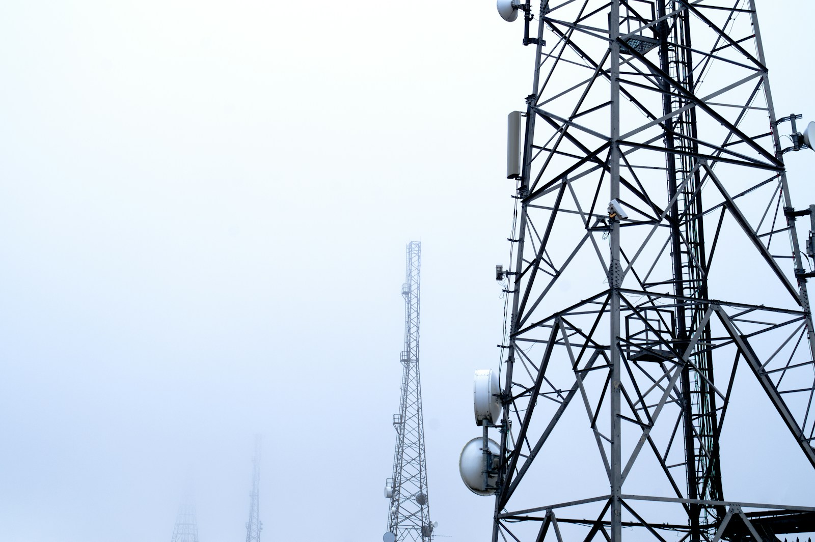 Telecoms masts against a misty sky